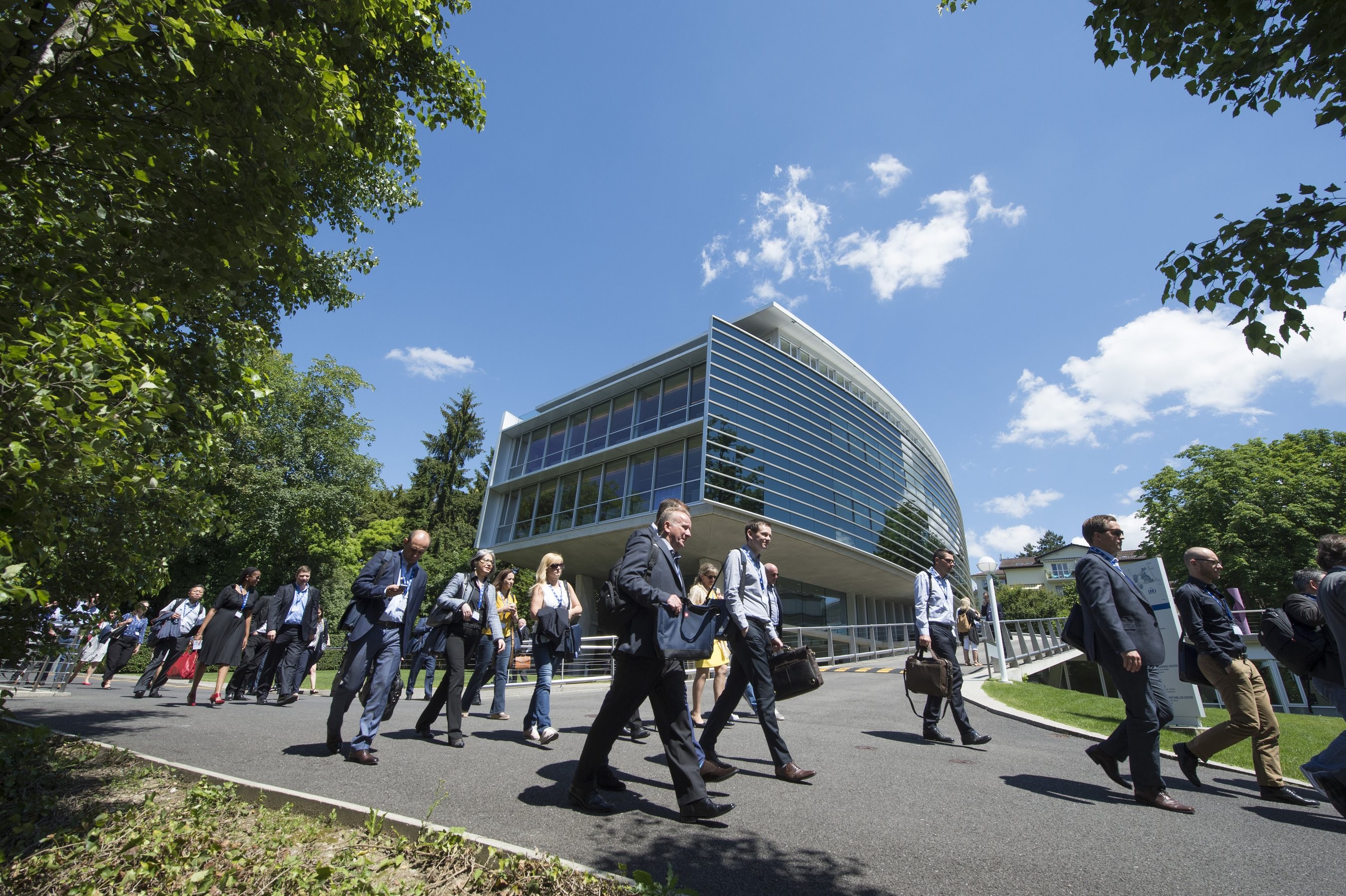 Students walking outside on a sunny day on the IMD campus