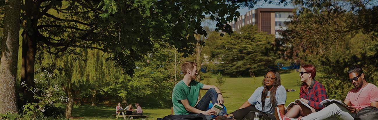Students sitting outside laughing on the University of Birmingham campus