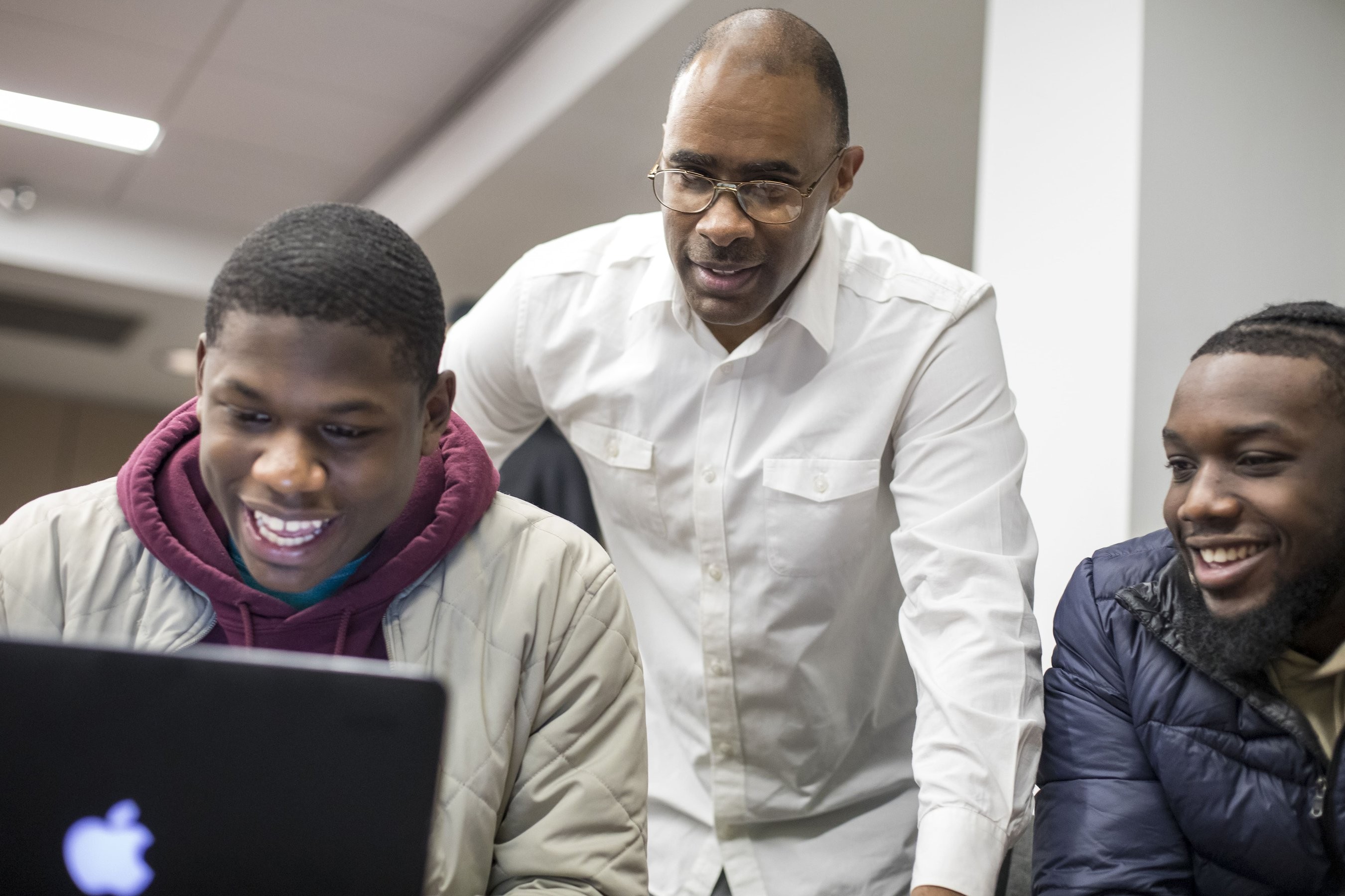 Students and professor working on a computer at Morehouse College