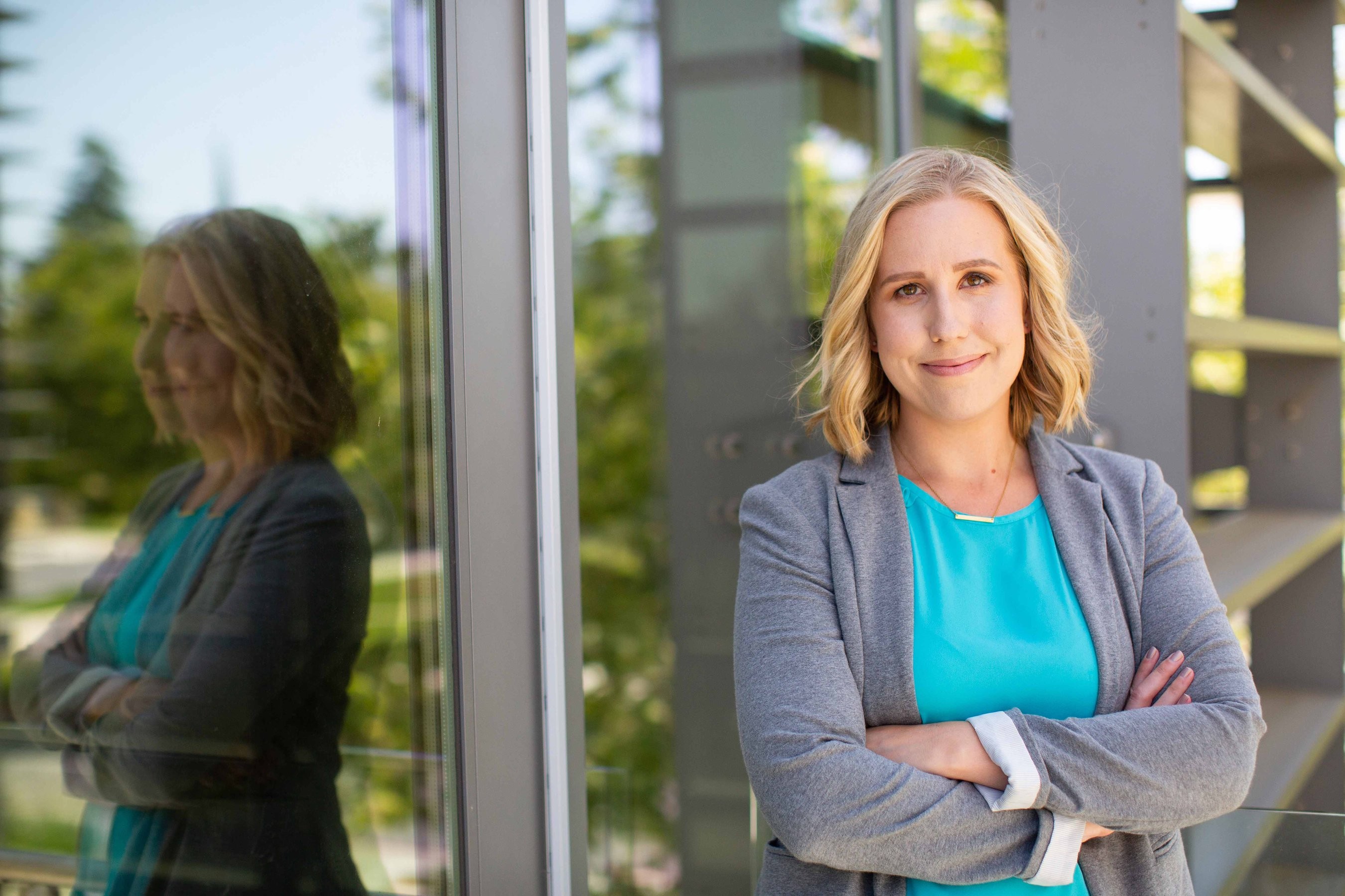 Woman smiling and posing for a photo in front of the UC Davis School of Management building