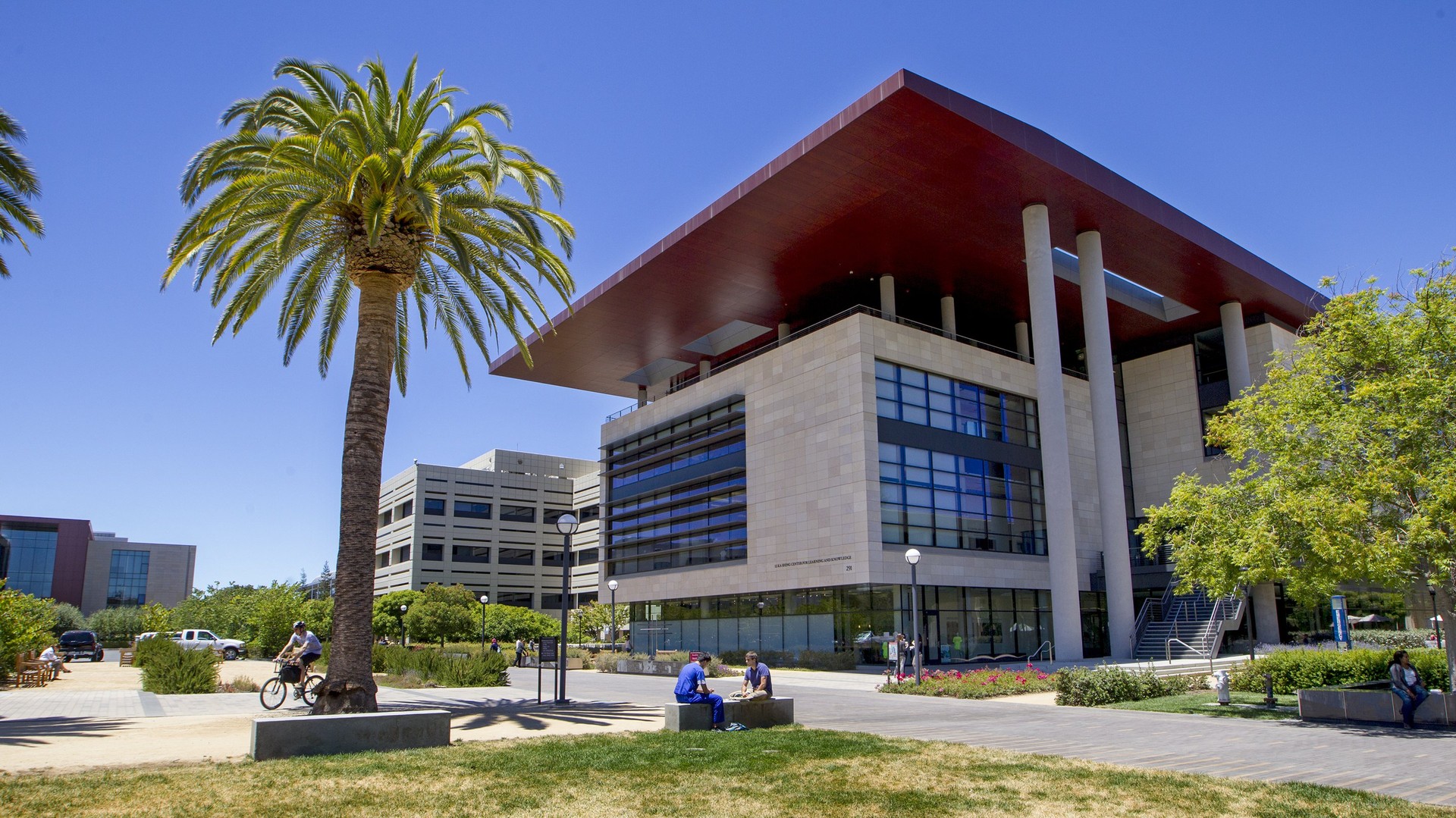 Building on Stanford University on a sunny day with students sitting outside