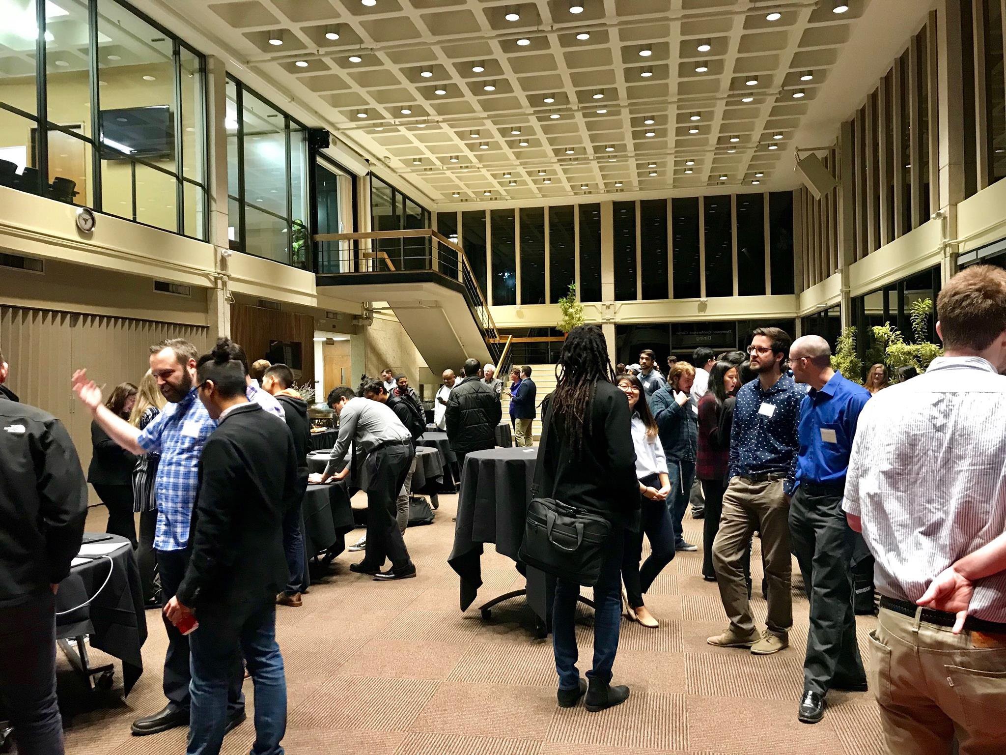 Students at a UT Austin demo days in the lobby of a building talking