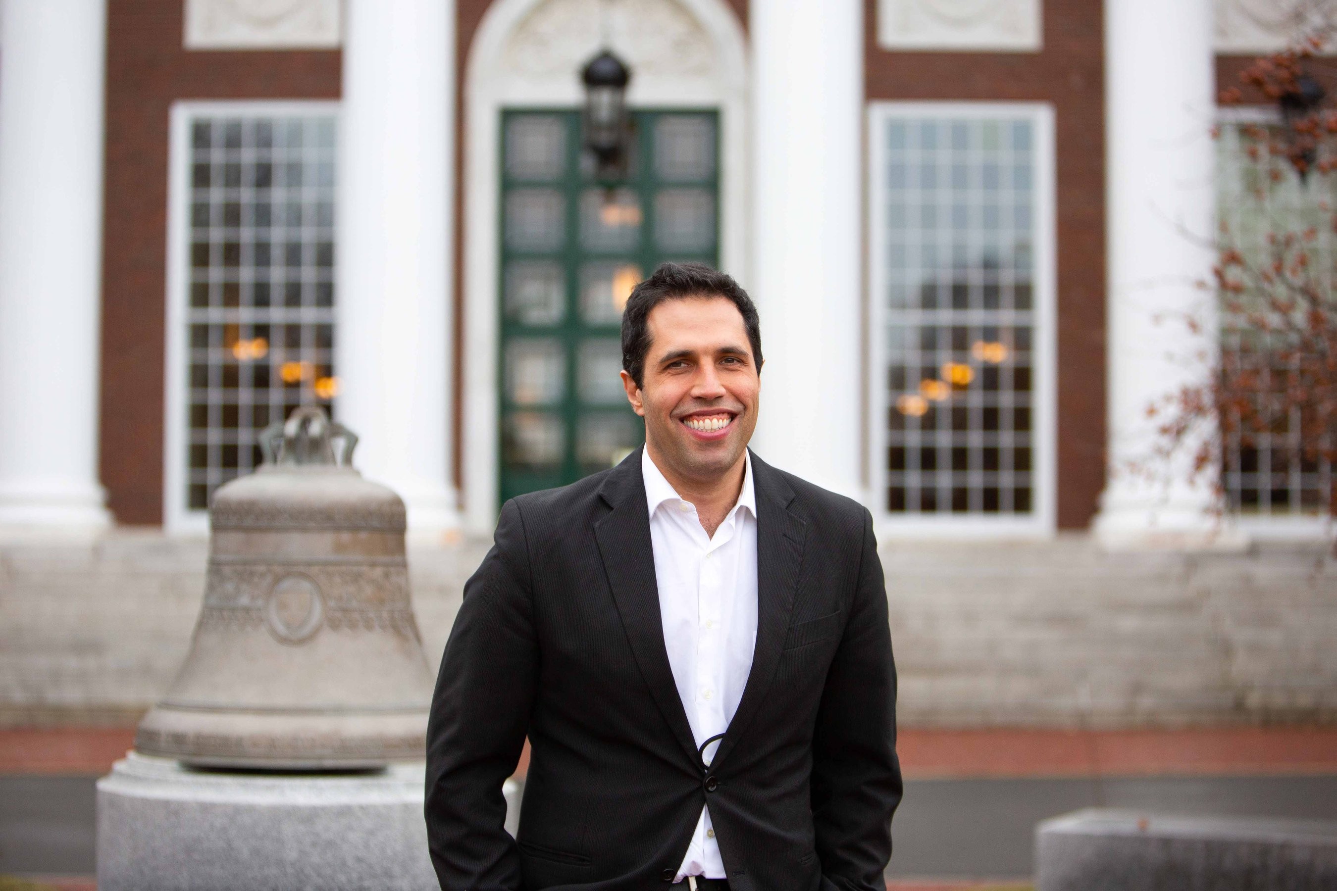 Harvard student poses for a photo at in front of the Baker Library Bell at Harvard University