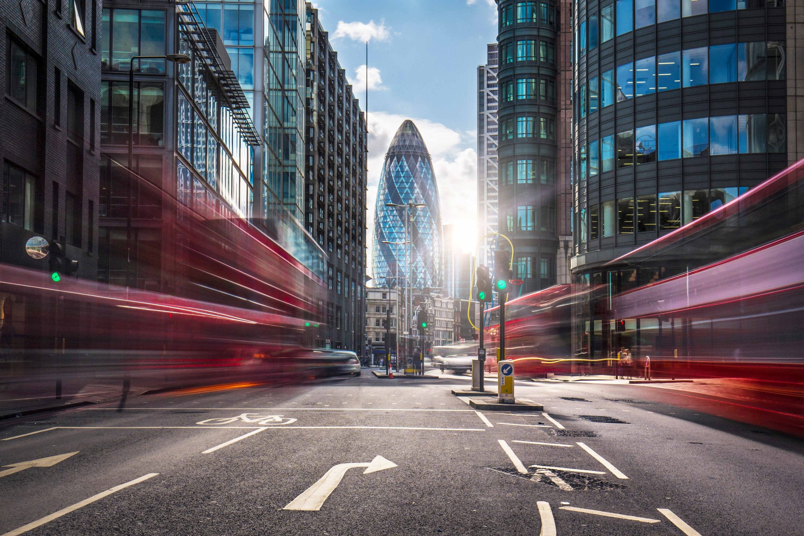 Long exposure photo of a street in London with blurry lights leading up to The Gherkin building