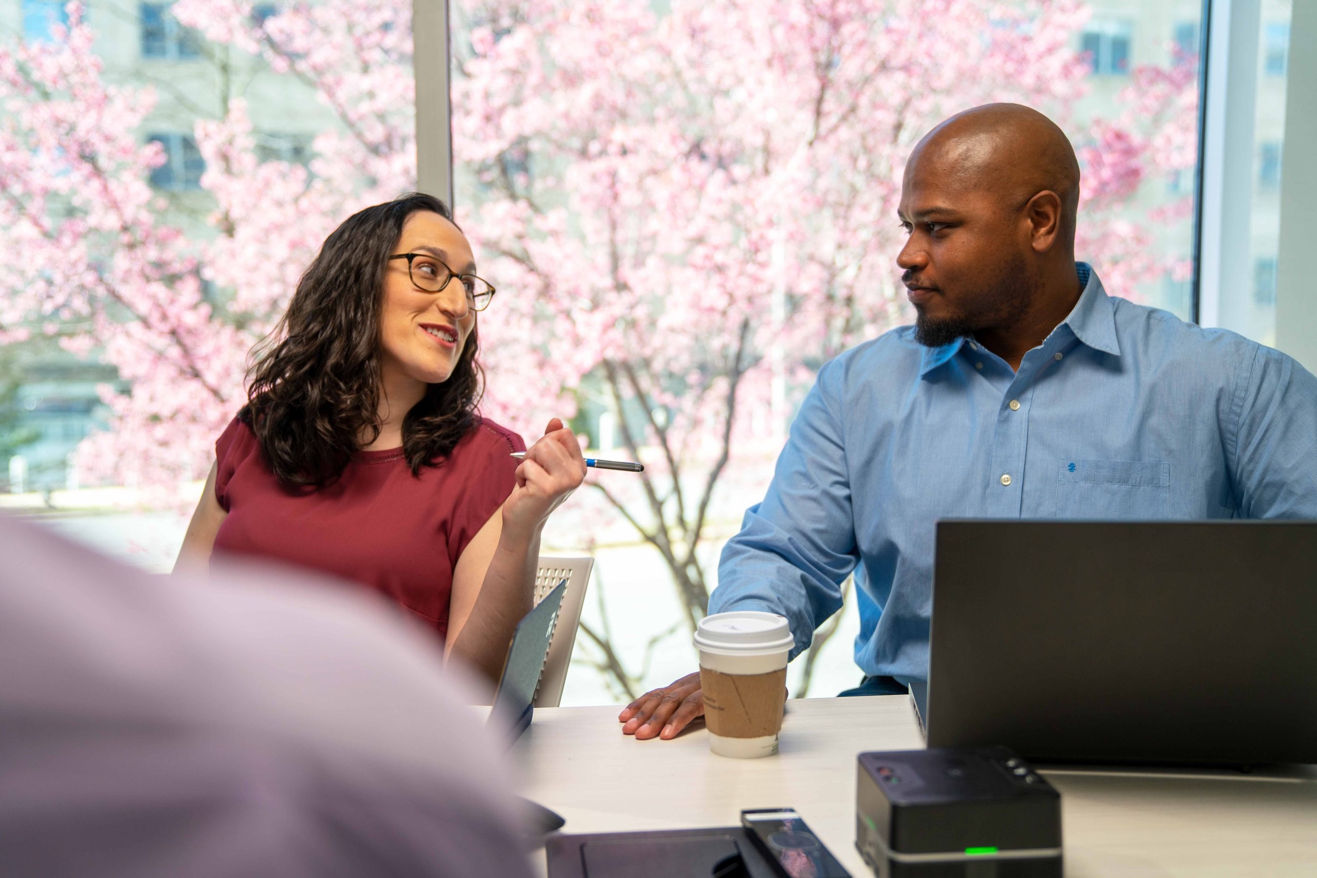 A pair of co-workers make eye contact during a meeting