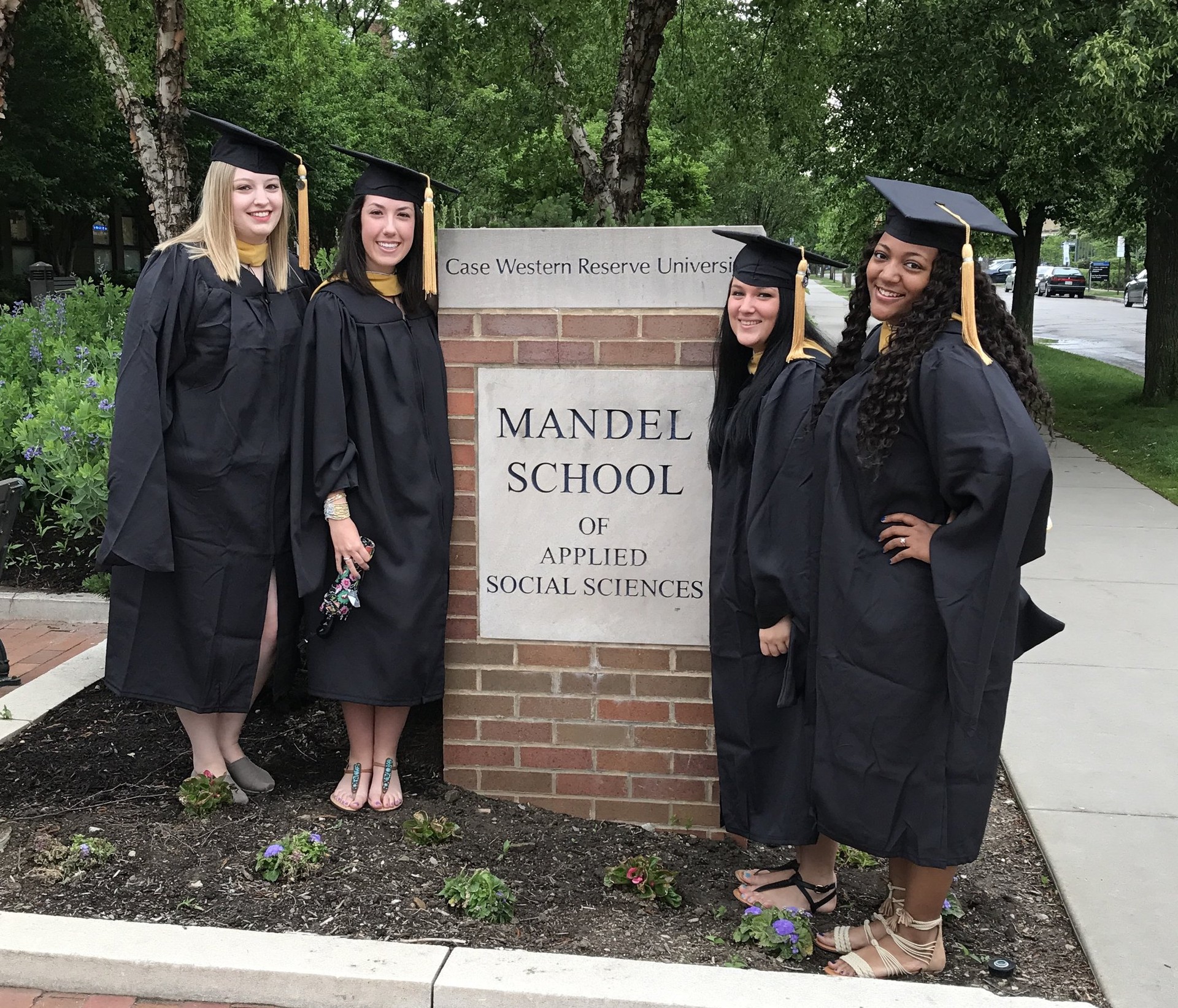 Graduates standing next to Mandel School of Applied Sciences sign